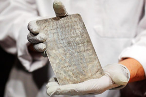 Boston MFA conservator Pam Hatchfield holding an engraved silver plate from the time capsule, which is thought to be the work of Paul Revere. (Credit: Reuters)